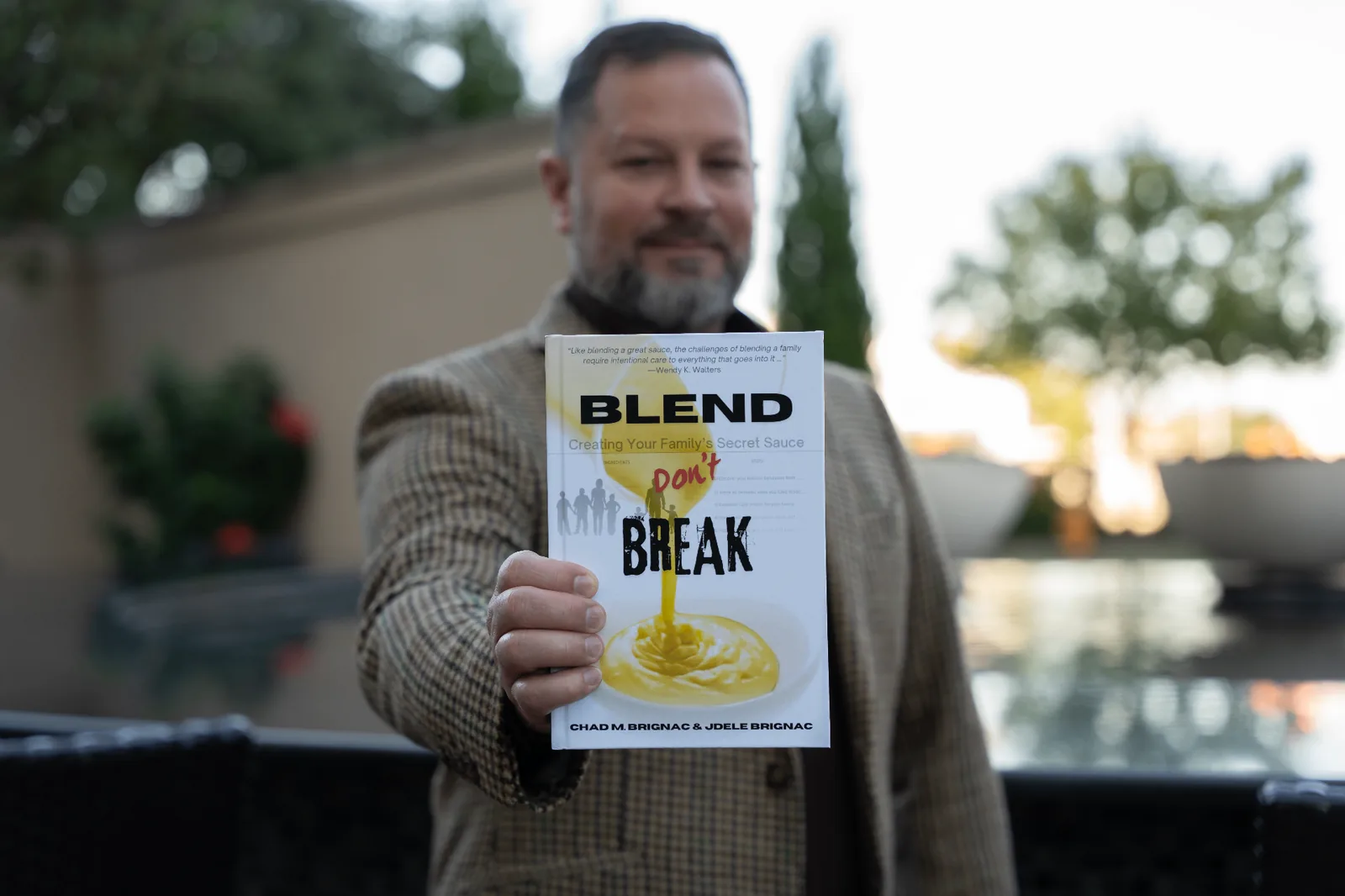 Chad M. Brignac holding his book Blend Don't Break: Creating Your Family's Secret Sauce